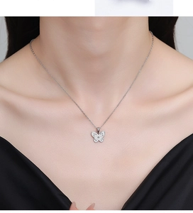 Close-up of minimalist S925 sterling silver butterfly pendant necklace on female model