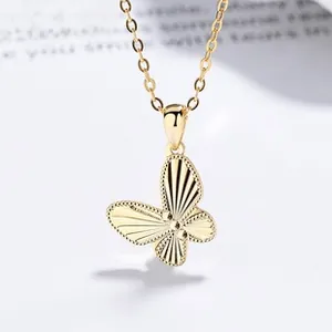Détail d'un pendentif papillon en argent 925 avec textures rayonnantes et fini doré