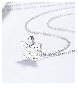 Detail of 925 sterling silver butterfly pendant with textured wings on a thin O-chain