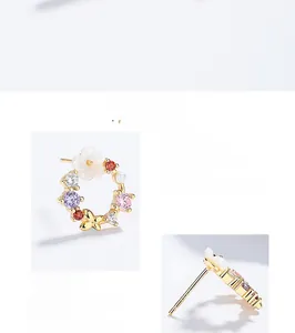 Macro detail of S925 silver flower stud earring with butterfly and colored zircons