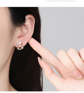 Macro side view of 925 silver earring featuring colorful zircon wreath and white flower