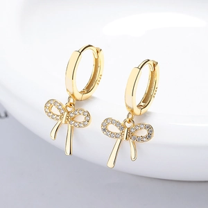 925 silver gold bow earrings with micro-pave zircons and round clasp on white surface