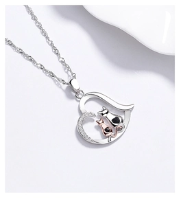 Macro detail of 925 silver heart pendant with cats and sparkling zircon stones