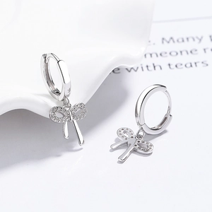 925 silver bow earrings with sparkling cubic zirconia on a minimalist white tray