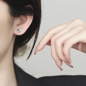 Boucles d'oreilles papillon en argent S925 avec zircons portées par un mannequin