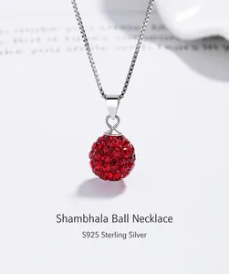 Vue macro d'un collier en argent sterling S925 avec pendentif boule en cristaux rouges