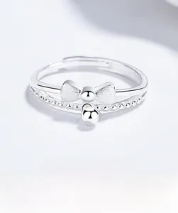 Close-up of 925 silver brushed bow ring with hanging bead detail and beaded band