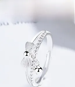 Macro shot of S925 sterling silver bow ring with hanging bead and multi-layer plating
