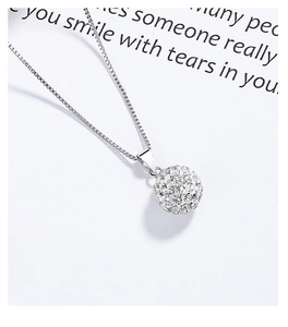 Gros plan d'un collier en argent 925 avec pendentif boule serti de cristaux sur carte