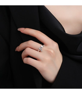 Close-up of S925 silver bow ring with dangling bead and zircon inlay on finger