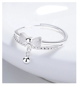 Close-up of 925 silver bow ring featuring brushed texture and a polished bead charm