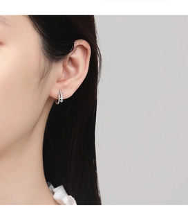 Gros plan de créoles en argent sterling 925 avec zircons pavés sur l'oreille du modèle