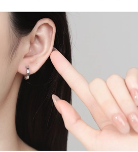 Detailed view of silver hoop earring featuring an eight-pointed star with zircons