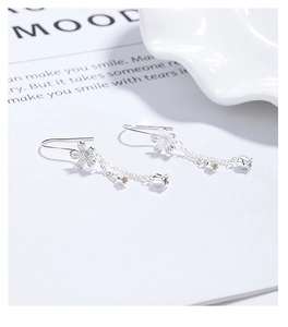 Close-up of 925 silver camellia earrings with elegant tassel and bell detail
