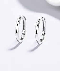Makroaufnahme minimalistischer 999 Silber gedrehte Creolen mit polierter Metalltextur
