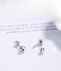 Macro view of 925 sterling silver lightning bolt studs with a red gemstone and screw back