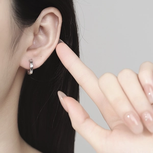 Elegant 925 sterling silver star-engraved hoop earrings on model with zircon details