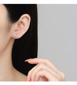 Detailed view of sterling silver crown stud earring with sparkling cubic zirconia on ear