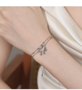 Detailed view of silver double-layer bead bracelet with ruyi lock pendant on silk