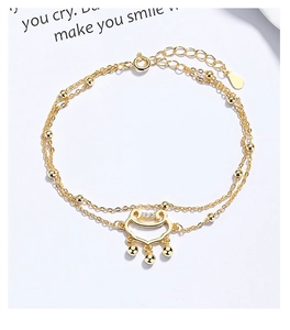 Detailed shot of double-layered gold bracelet with safety lock charm and tiny beads