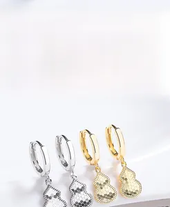 Macro shot of 925 silver gourd hoop earrings with textured scales in gold and silver