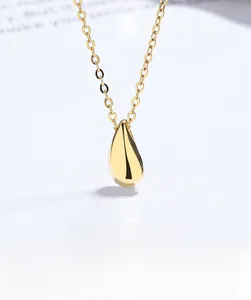 Macro shot of polished gold teardrop pendant on link chain with elegant studio lighting