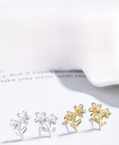 Detailed macro of S925 silver flower earrings in gold and silver plating