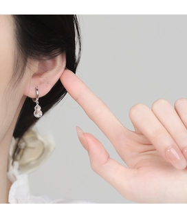 925 sterling silver gourd earrings inlaid with sparkling white zircons on model's ear