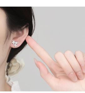 Close-up of 925 sterling silver flower earrings worn by a model in a side view