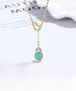 Vue macro du pendentif double gourde doré avec calcédoine verte et zircons brillants