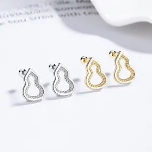 Macro detail of silver and gold hulu earrings with freshwater pearl and zircon accents
