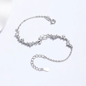 Eleganteres S925 Sterlingsilber-Schleifenarmband mit Zirkonia auf weißem Seidenhintergrund
