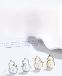 Macro shot of 925 silver gourd earrings with freshwater pearl and zircon stones