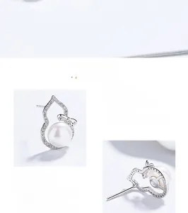 Detail view of 925 sterling silver gourd earrings with freshwater pearl and zircon inlay