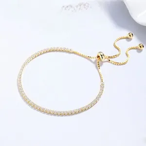 Macro view of adjustable gold-plated tennis bracelet featuring white zircons and sliding clasp