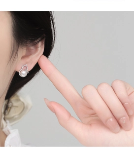 Detail of S925 silver gourd earring with freshwater pearl and zircon on model's ear