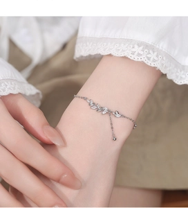 Close-up of 925 sterling silver wheat leaf bracelet with zircon stones on model's wrist