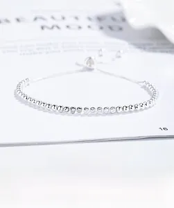 Detail of adjustable 925 silver beaded bracelet with sliding clasp on stylish magazine card