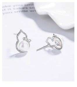 Macro view of sterling silver hulu earrings featuring freshwater pearls and zircon bow detail