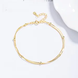 Detailed shot of double-layered S925 sterling silver gold bracelet with smooth beads