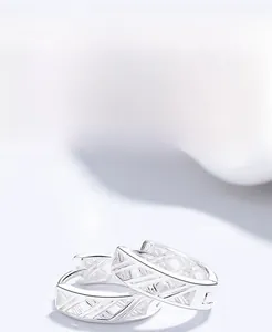 Detail of S999 sterling silver knot earrings showing cross design and polished finish
