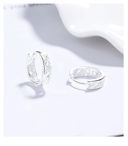 Macro detail of S999 sterling silver hoop earrings with hollow cross weave texture