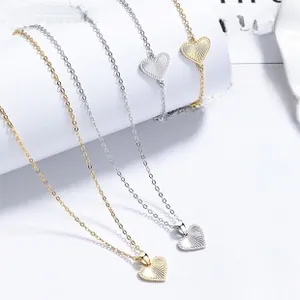 Detail of hollow heart pendant necklace and bracelet set in gold and silver finish