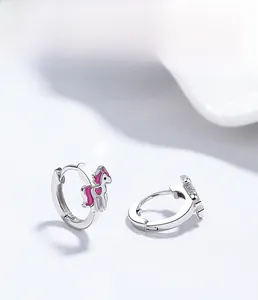 Vue macro de boucles d'oreilles licorne en argent S925 avec détail cœur en émail