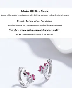 Détail de boucles d'oreilles licorne en argent 925 avec cœur en émail rose et placage