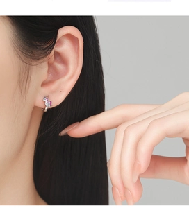 Vue rapprochée d'une boucle d'oreille licorne en argent 925 avec émail rose et blanc