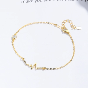 Gold ECG heartbeat bracelet with zircon stone on a minimalist white background