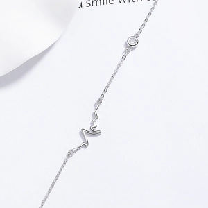 Minimalist 925 sterling silver heartbeat bracelet with zircon on a white background