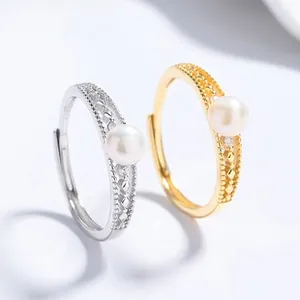 Detailed macro view of 925 silver and gold open rings with freshwater pearls and zircon