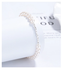 Close-up of 925 sterling silver and pearl bracelet on a minimalist white stand